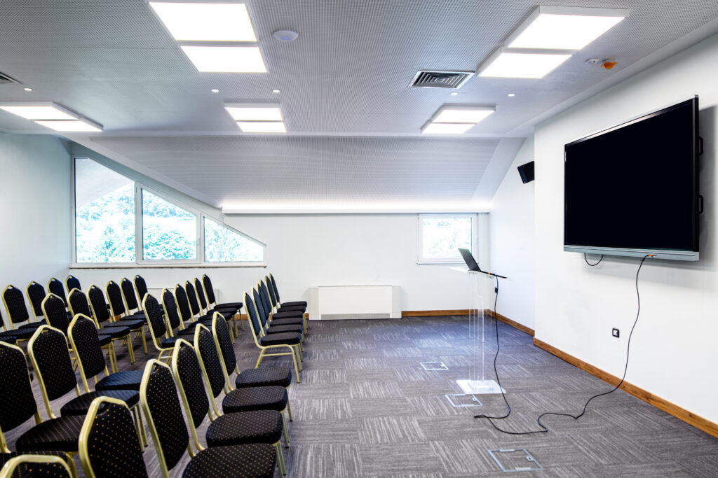 Sala de treinamento com cadeiras e tela para cursos da Conforlab Academia